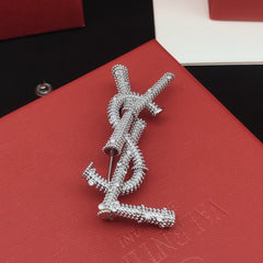 Broche de letra de cuerda trenzada con detalles de piedra