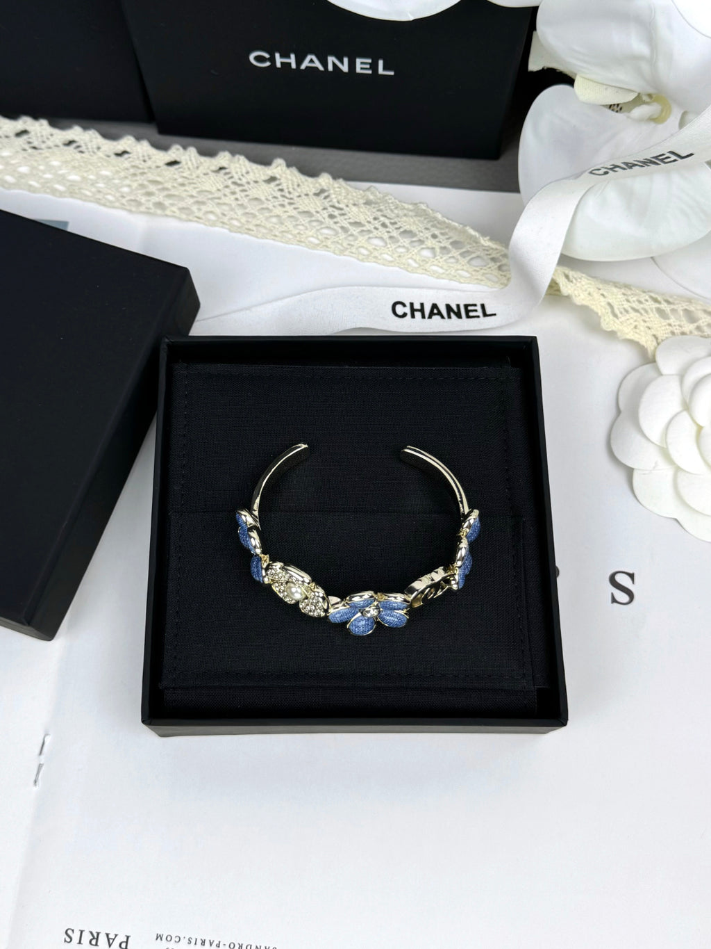 Pulseira rígida com flores azuis entrelaçadas em forma de C