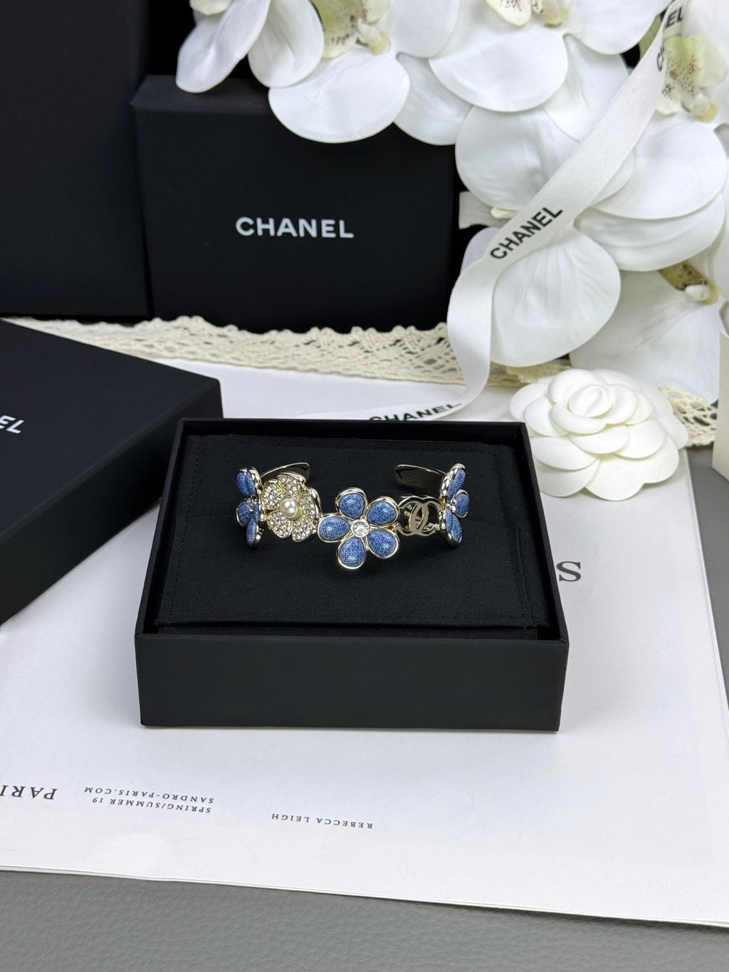Pulseira rígida com flores azuis entrelaçadas em forma de C