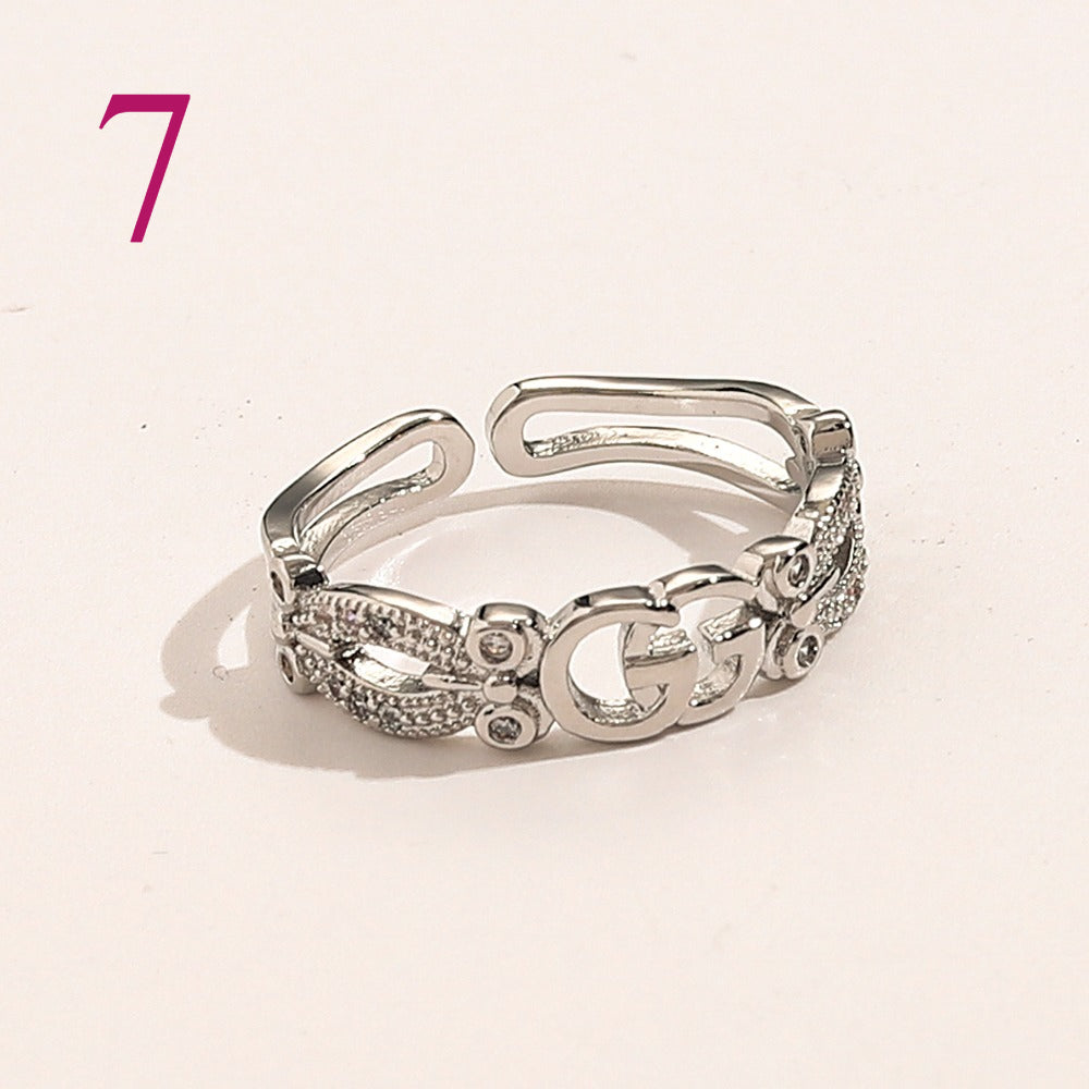 Anillo abierto texturizado con emblema entrelazado