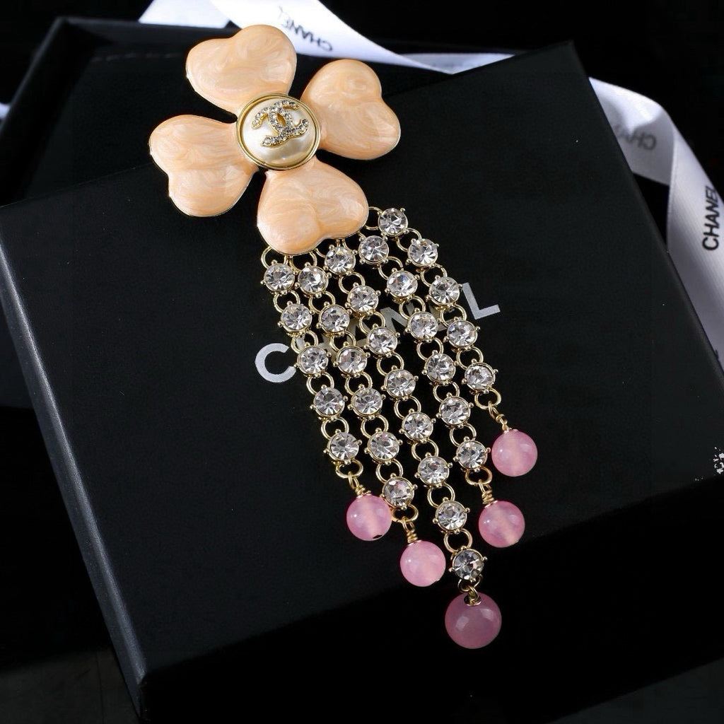 Broche fleurie avec chaîne en pierres et perles pendantes