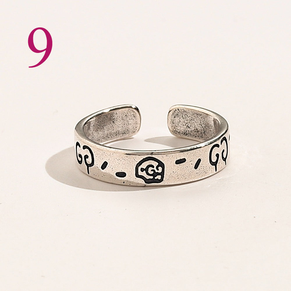 Anillo abierto texturizado con emblema entrelazado