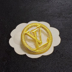Broche con emblema de letra redonda y borde de cuerda