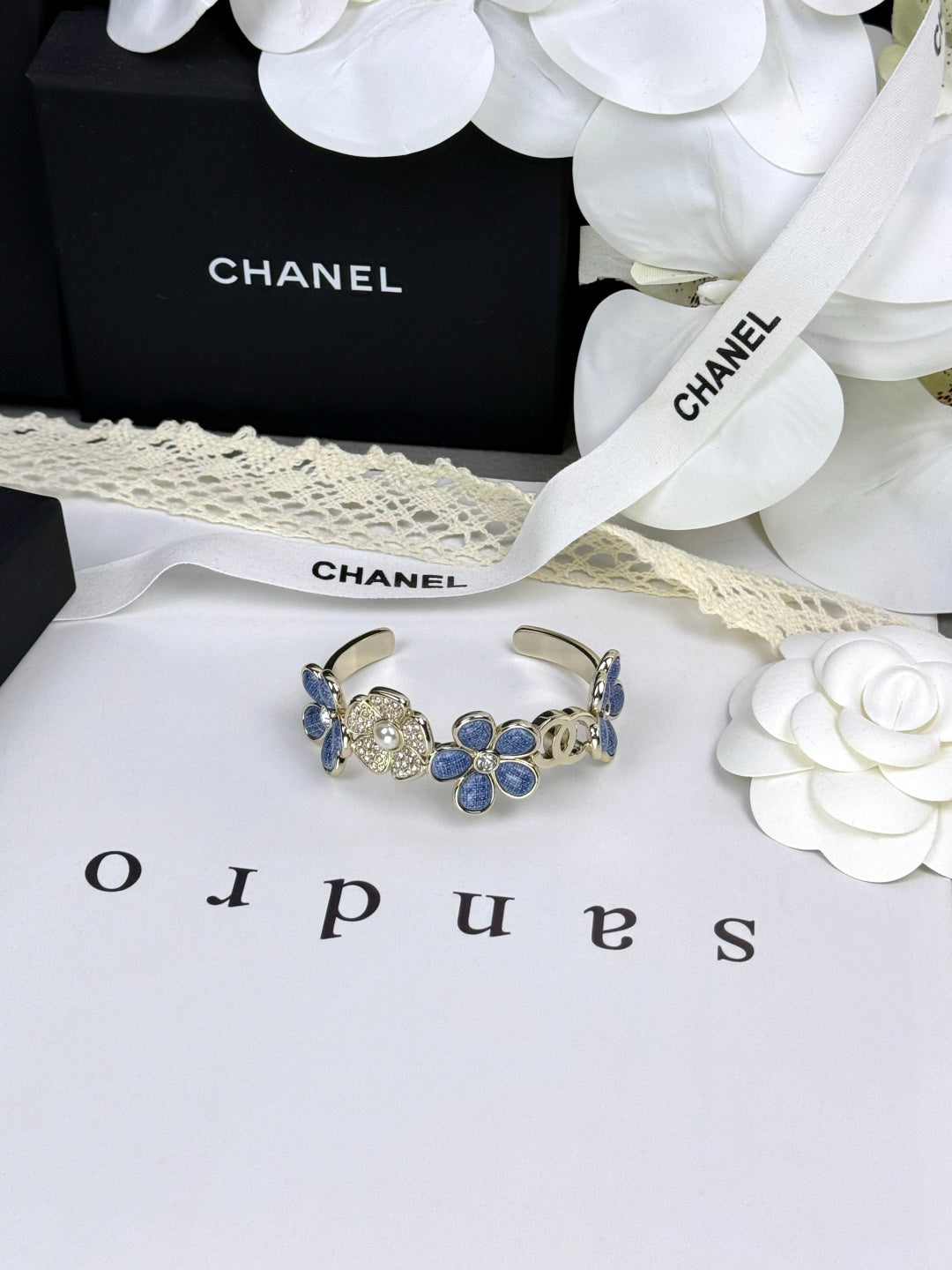 Pulseira rígida com flores azuis entrelaçadas em forma de C