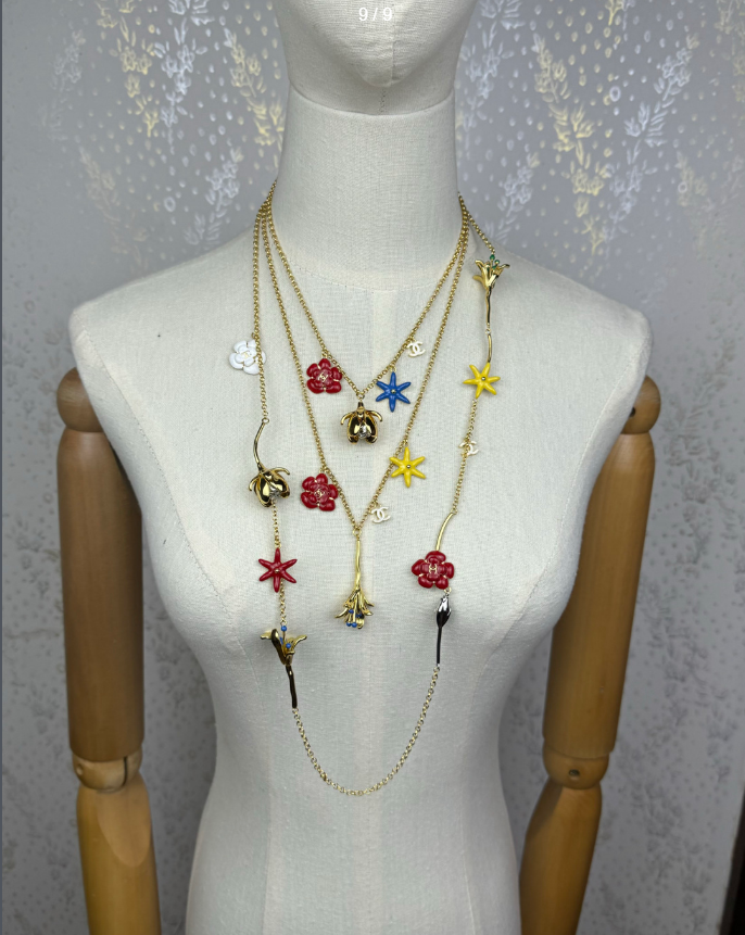 Colar comprido em tom dourado com pendente de flores em esmalte multicolorido