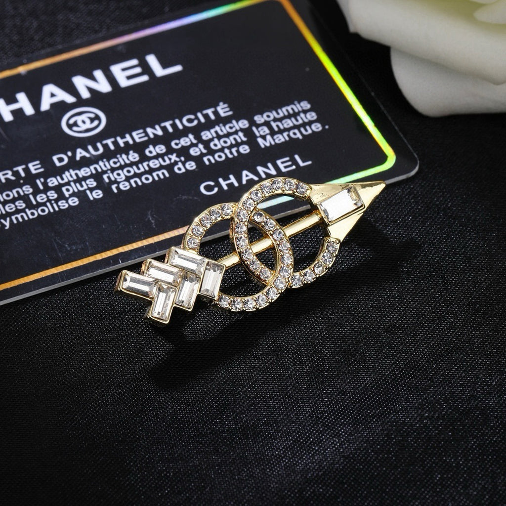 Broche de flecha y emblema con detalles en piedra