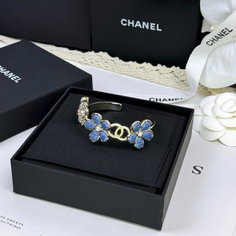 Pulseira rígida com flores azuis entrelaçadas em forma de C