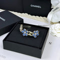Pulseira rígida com flores azuis entrelaçadas em forma de C