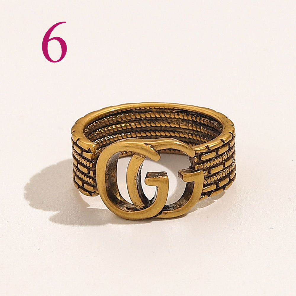 Anillo abierto texturizado con emblema entrelazado