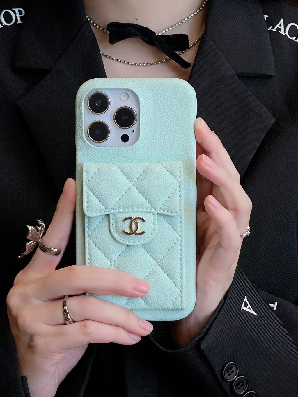 Funda acolchada para teléfono con cierre de emblema y cadena