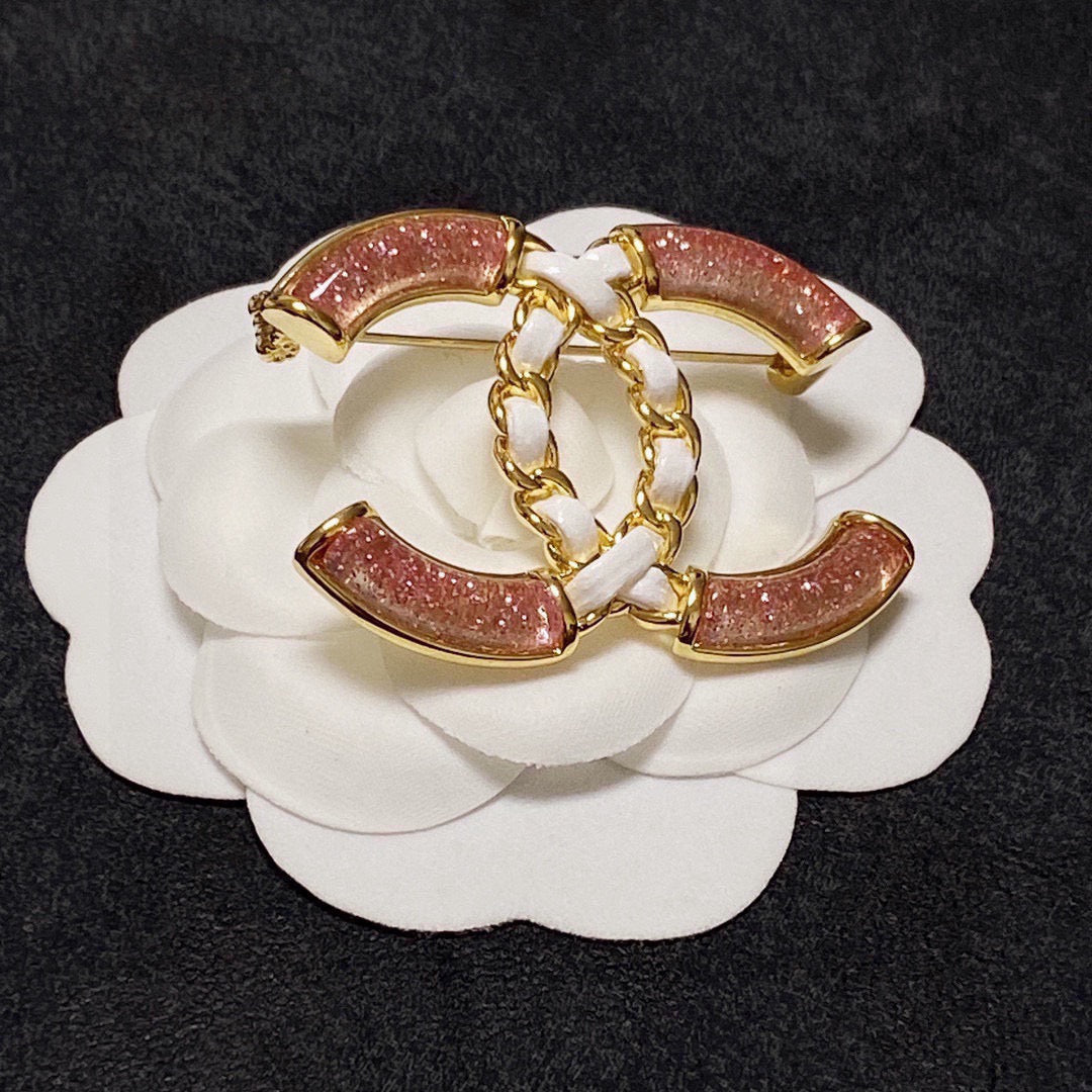 Broche de emblema con piedra rosa y eslabones trenzados