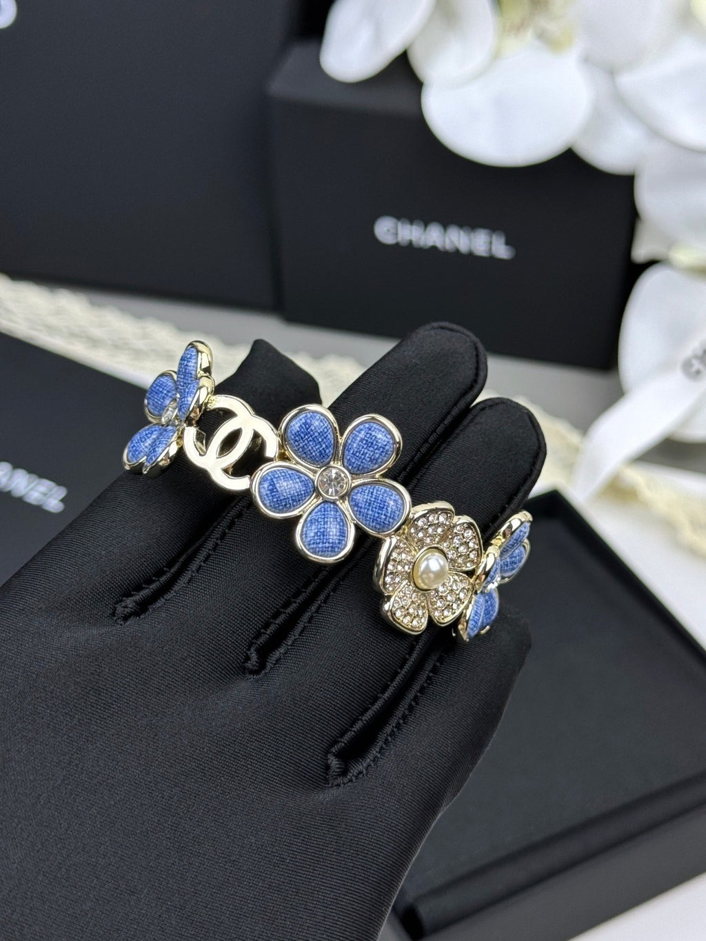 Pulseira rígida com flores azuis entrelaçadas em forma de C