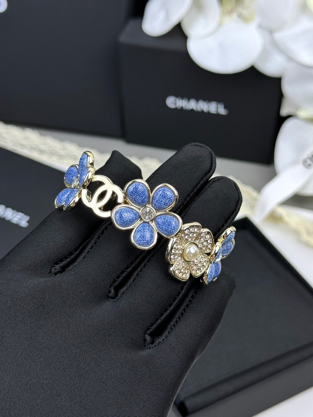 Pulseira rígida com flores azuis entrelaçadas em forma de C
