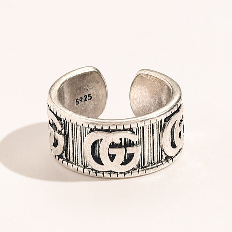 Anillo abierto texturizado con emblema entrelazado