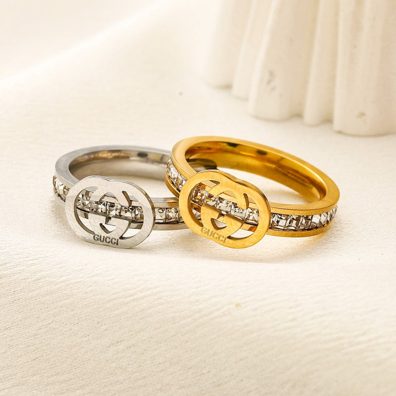 Anillo de banda con emblema fino y detalles en piedra