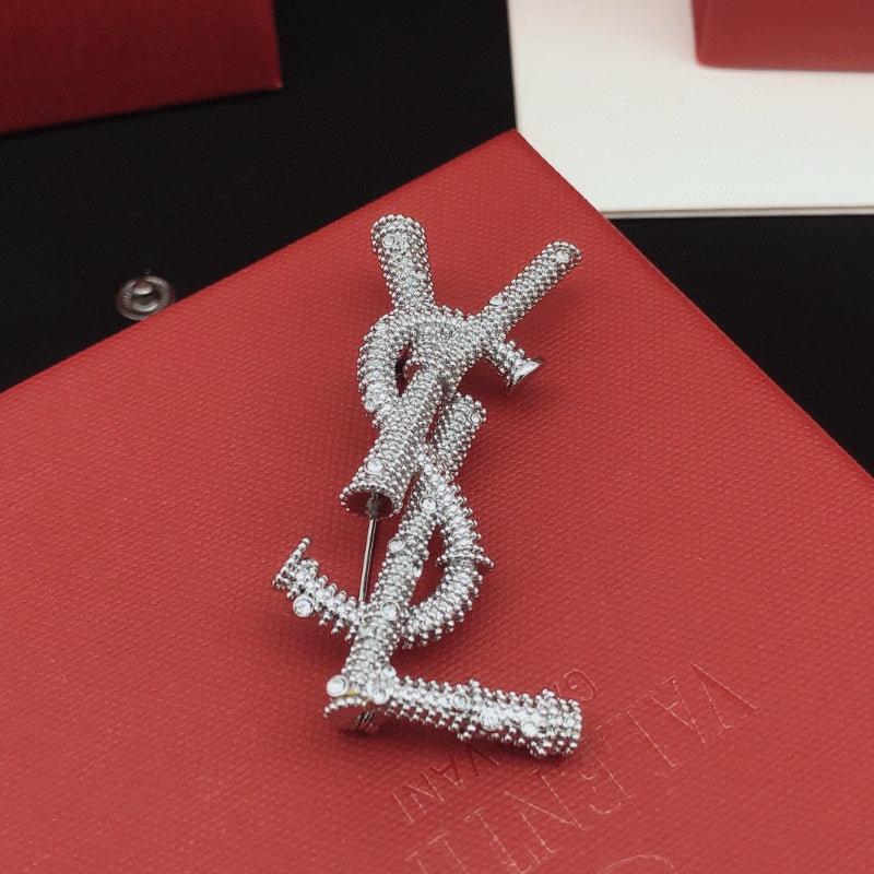 Broche de letra de cuerda trenzada con detalles de piedra