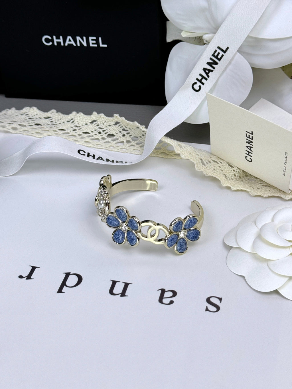 Pulseira rígida com flores azuis entrelaçadas em forma de C