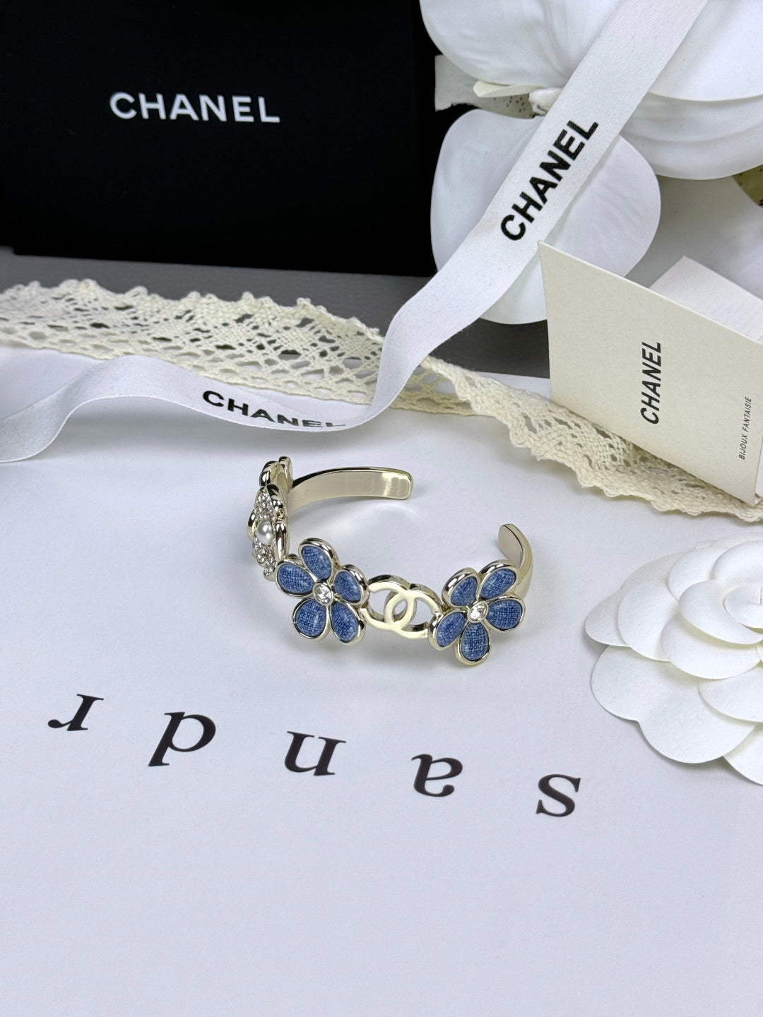 Pulseira rígida com flores azuis entrelaçadas em forma de C