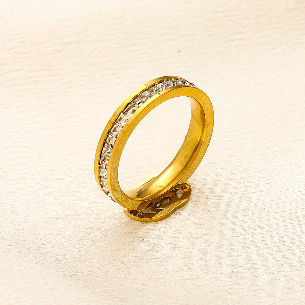 Anillo de banda con emblema fino y detalles en piedra