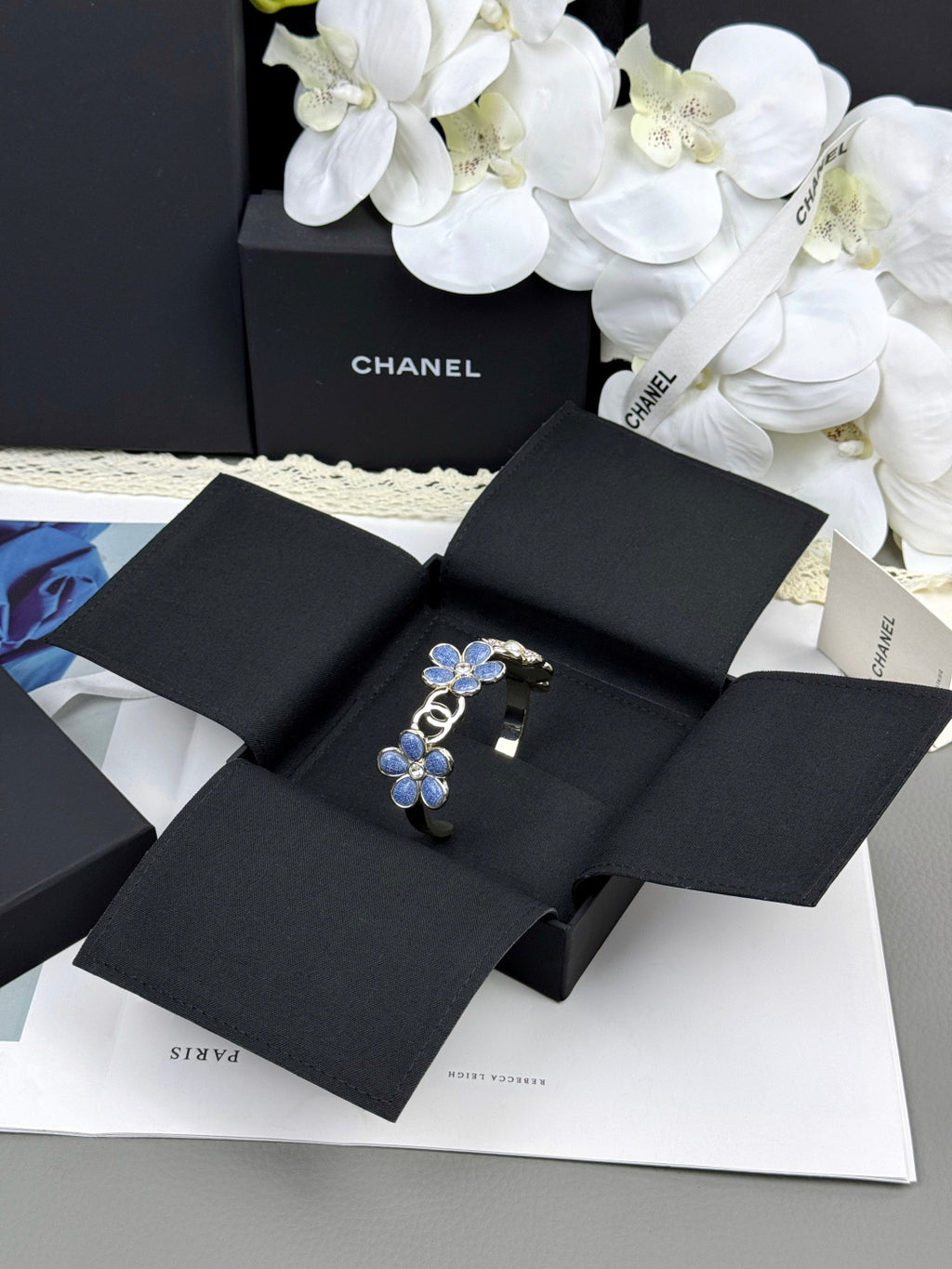Pulseira rígida com flores azuis entrelaçadas em forma de C