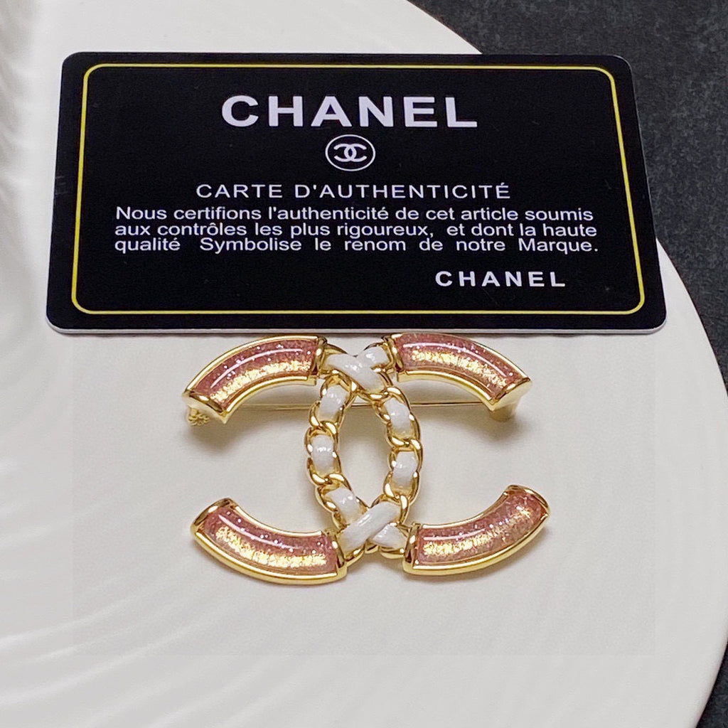 Broche de emblema con piedra rosa y eslabones trenzados