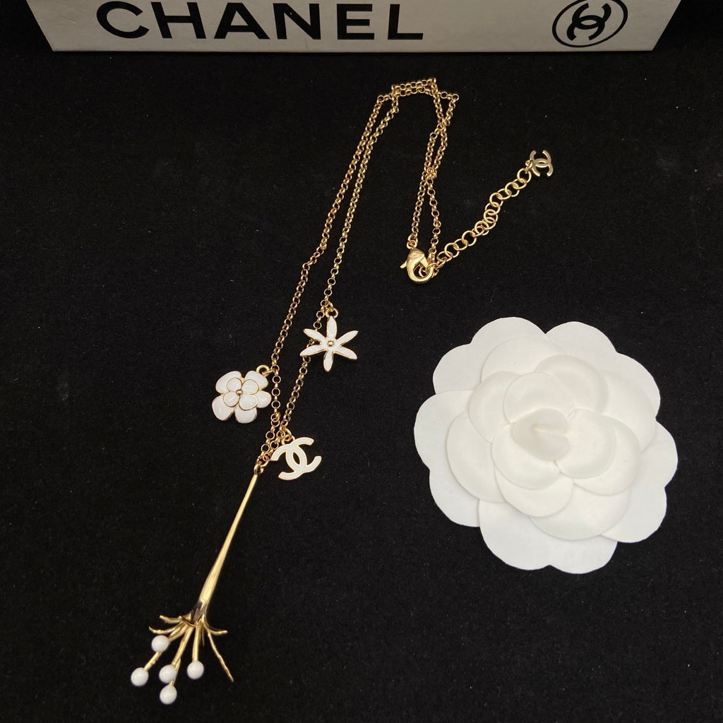 Collar tipo choker con dije floral esmaltado en tono dorado y detalles de perlas
