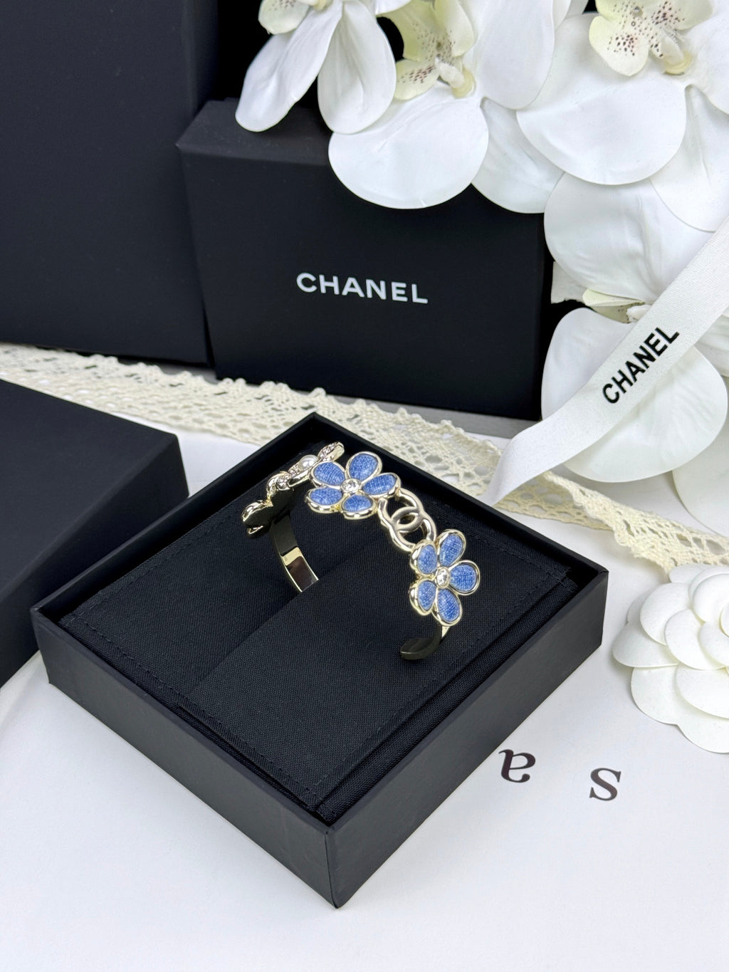Pulseira rígida com flores azuis entrelaçadas em forma de C