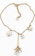 Collar tipo choker con dije floral esmaltado en tono dorado y detalles de perlas