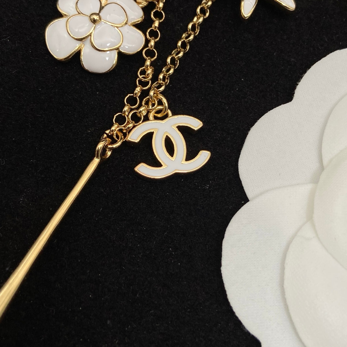 Collar tipo choker con dije floral esmaltado en tono dorado y detalles de perlas