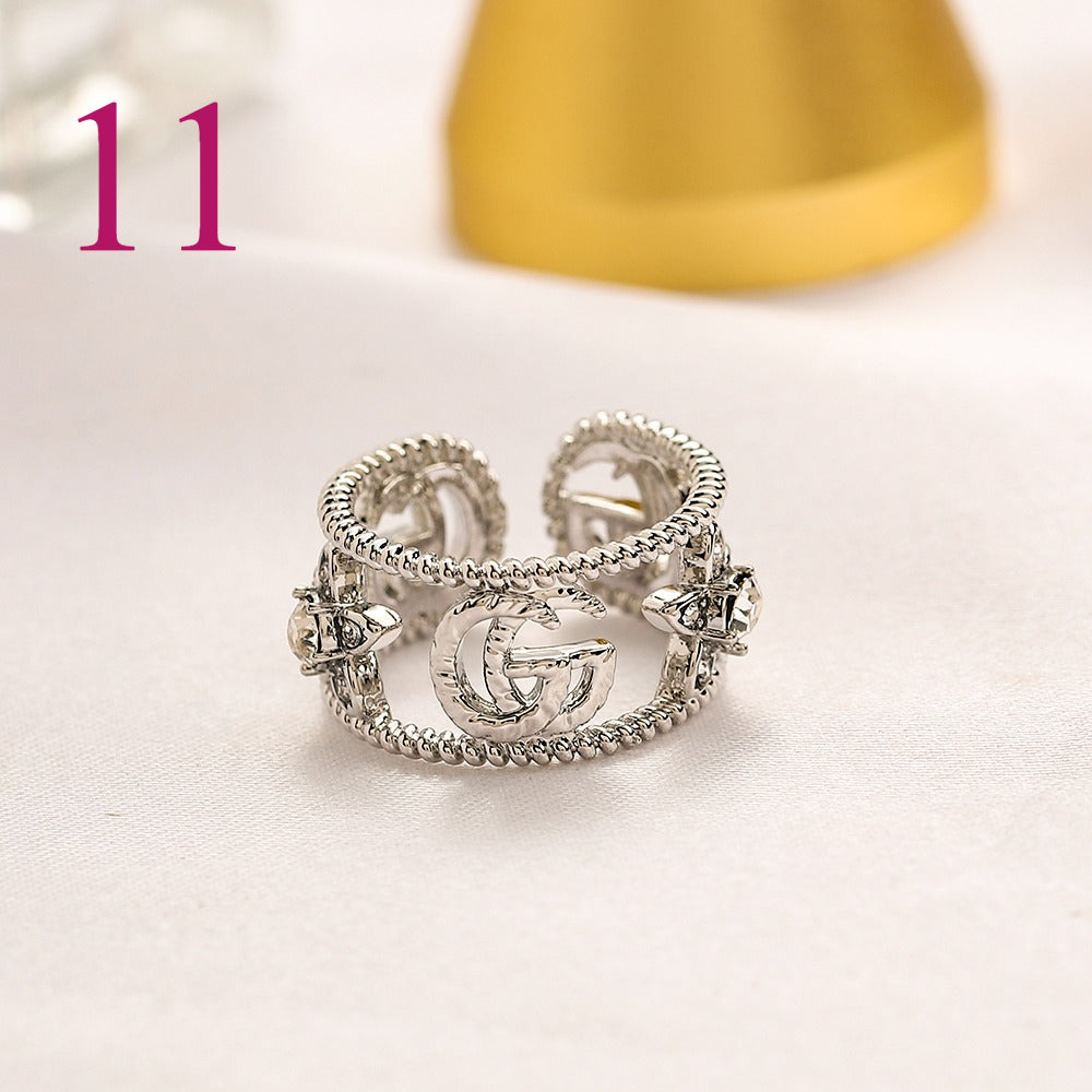 Anillo abierto texturizado con emblema entrelazado