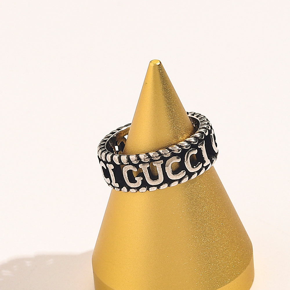 Anillo abierto con letras grabadas y bordes de cuerda