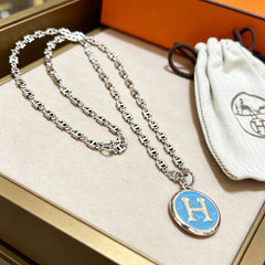 Collier chaîne épaisse avec médaillon H bleu