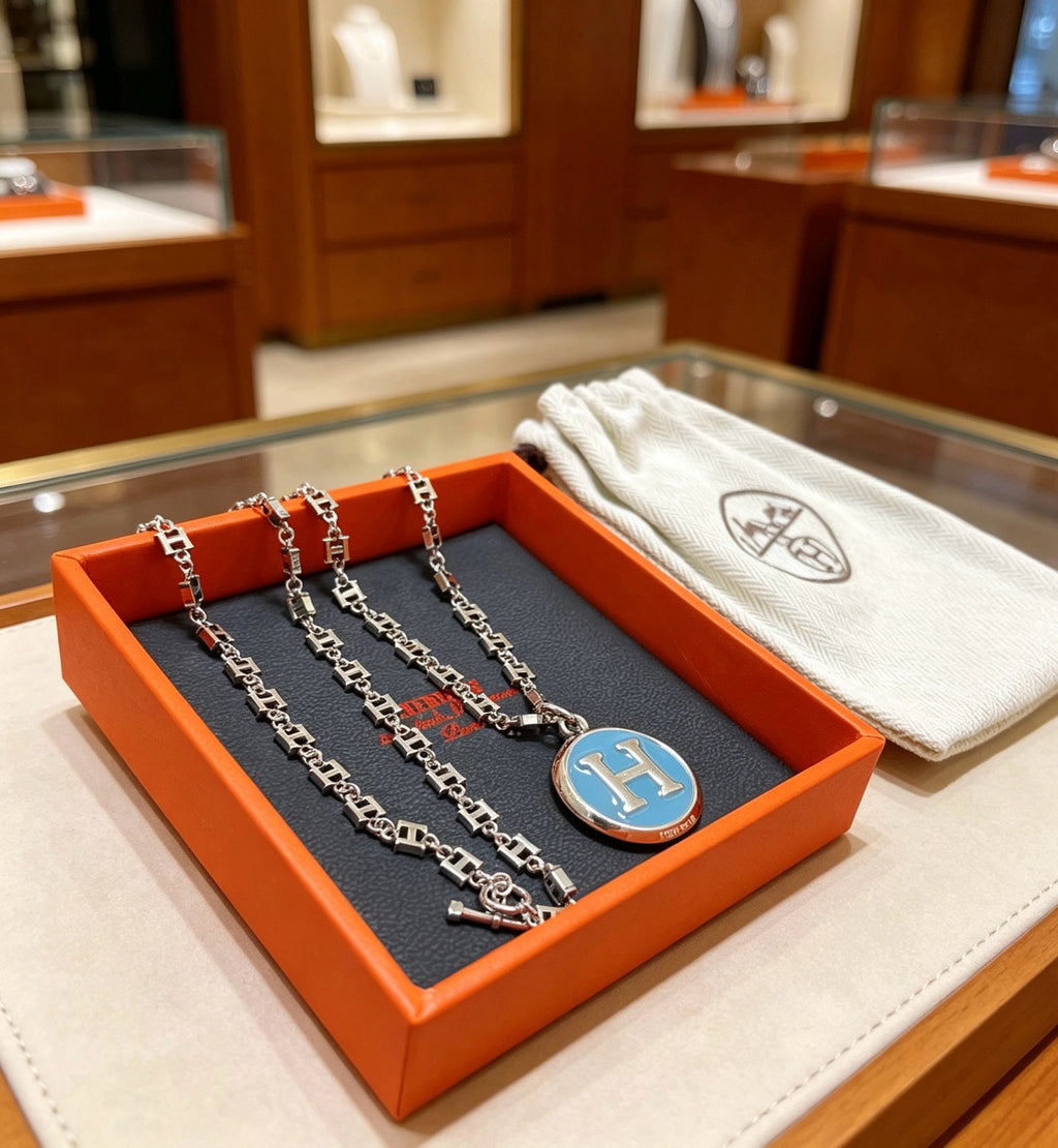 Collier chaîne épaisse avec médaillon H bleu