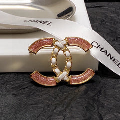 Broche de emblema con piedra rosa y eslabones trenzados