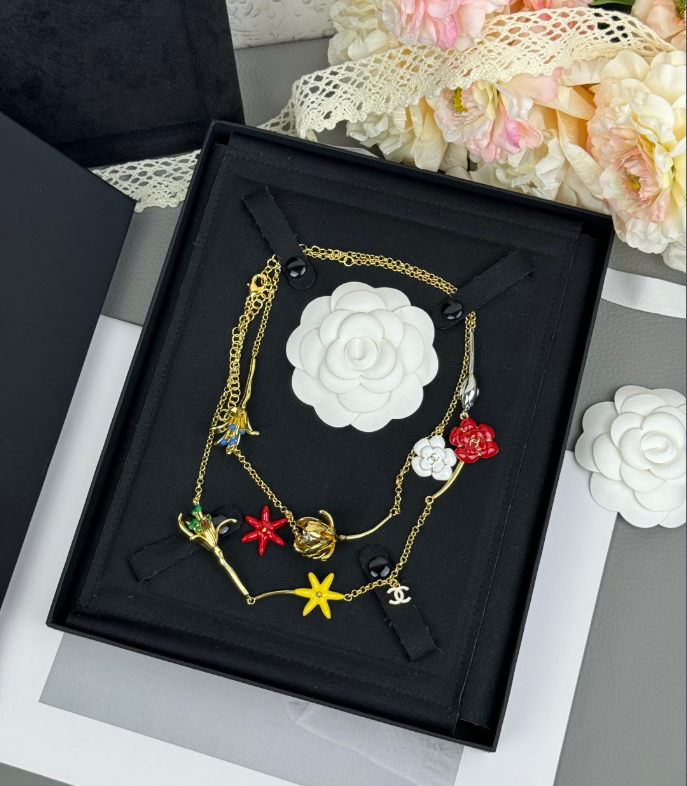 Colar comprido em tom dourado com pendente de flores em esmalte multicolorido