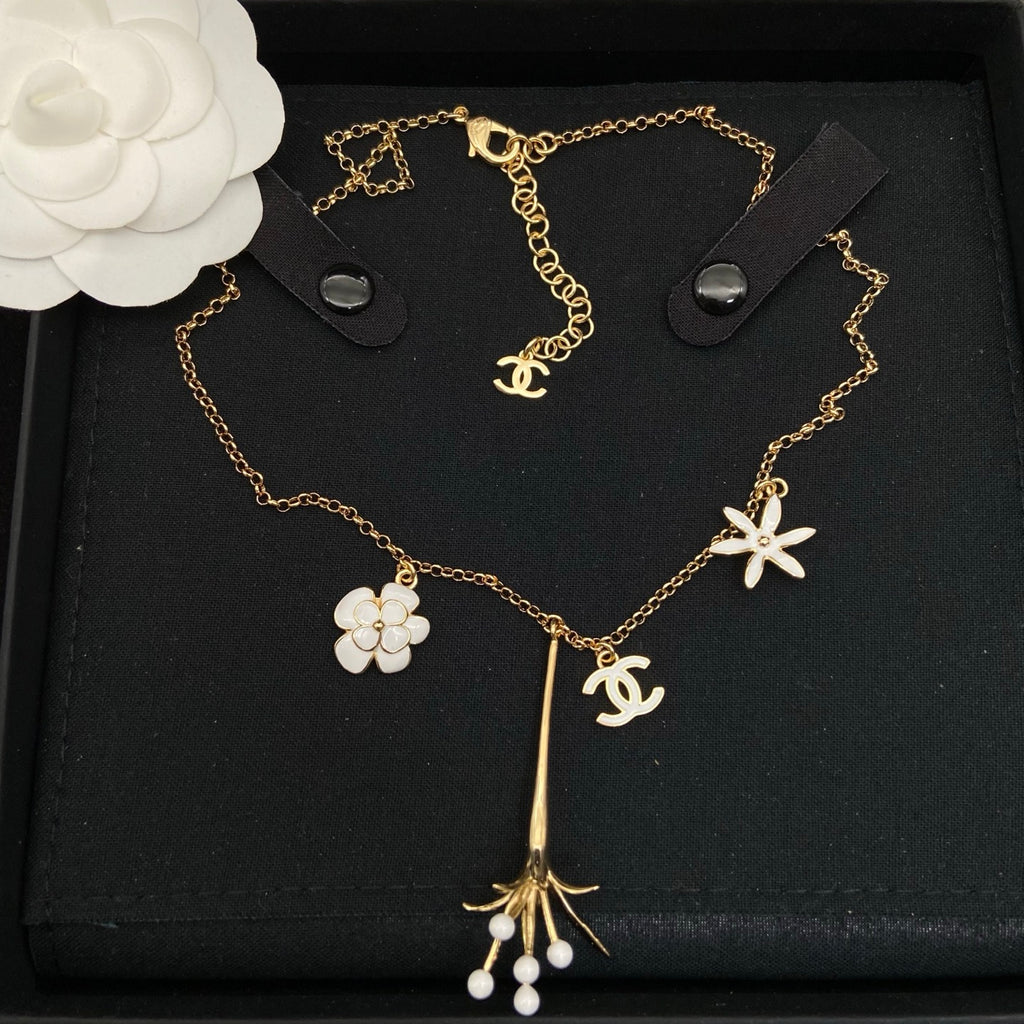 Collar tipo choker con dije floral esmaltado en tono dorado y detalles de perlas