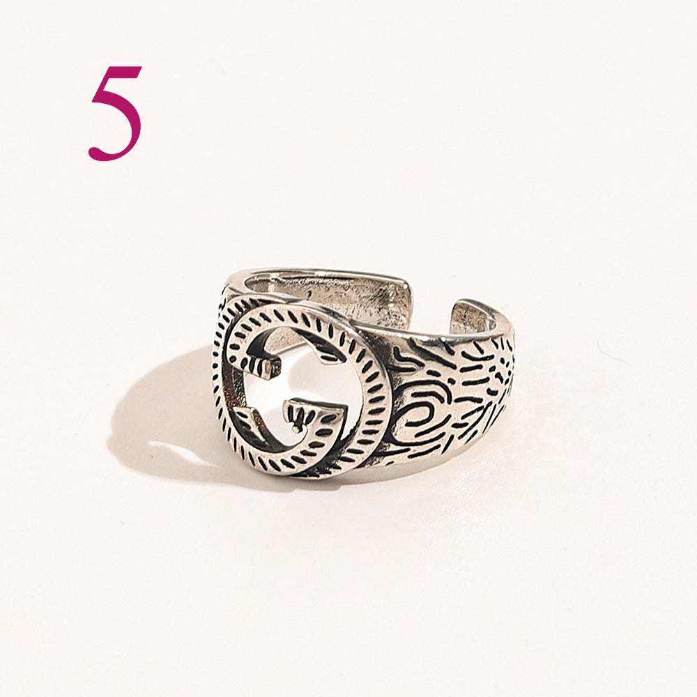 Anillo abierto texturizado con emblema entrelazado