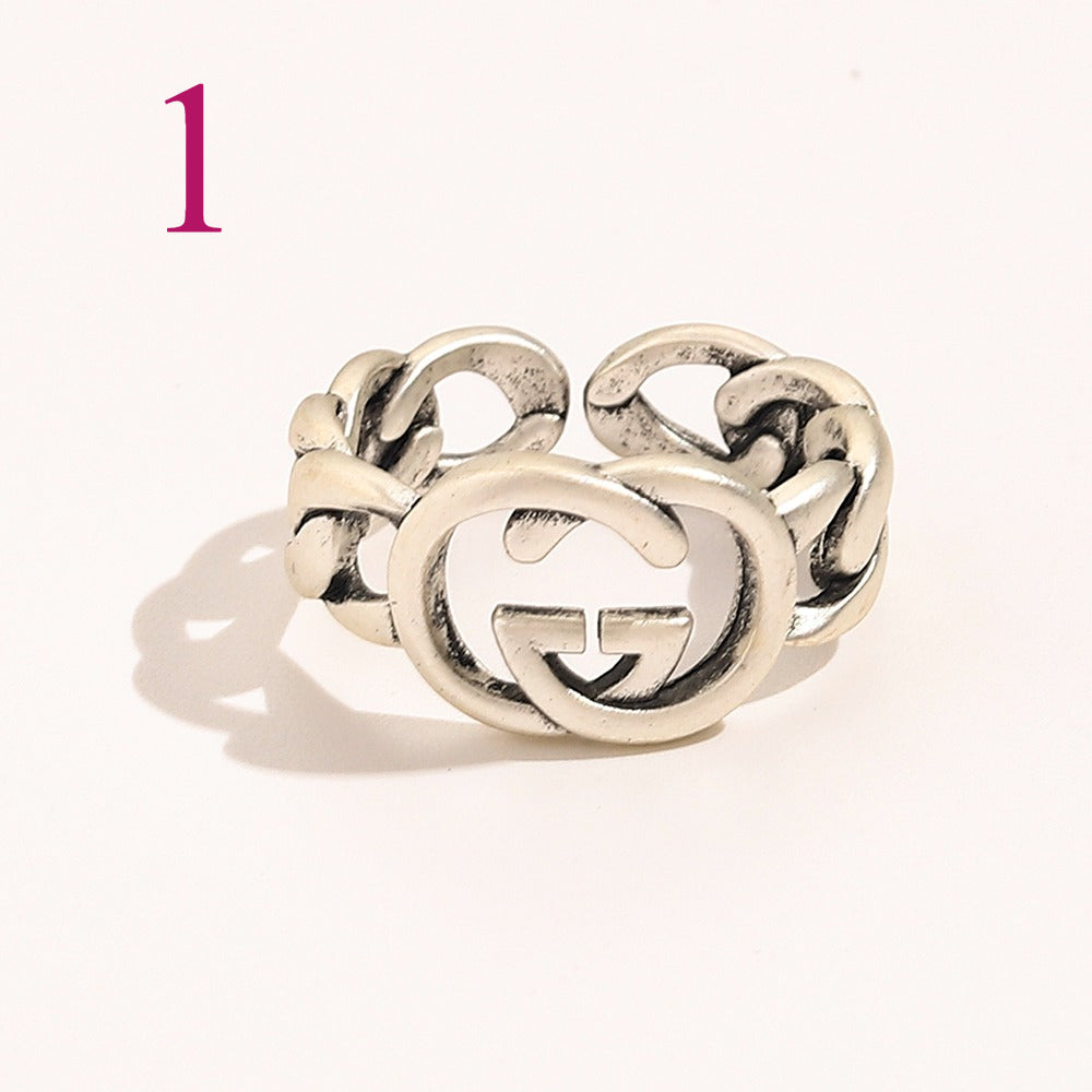 Anillo abierto texturizado con emblema entrelazado