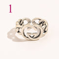 Anillo abierto texturizado con emblema entrelazado