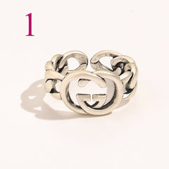 Anillo abierto texturizado con emblema entrelazado