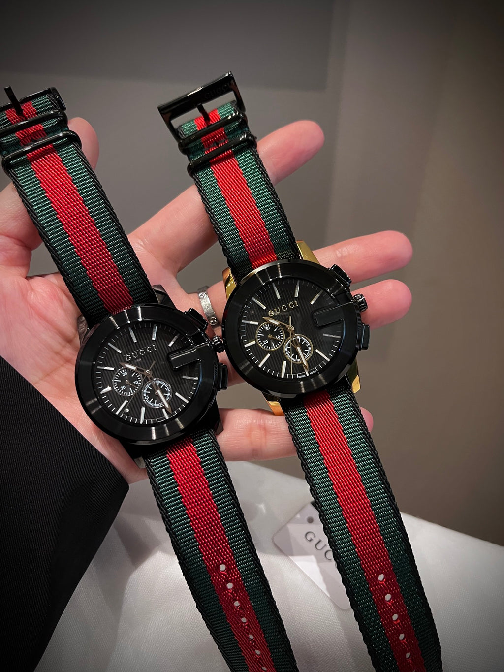 Black multi-dial watch with red and green striped strap