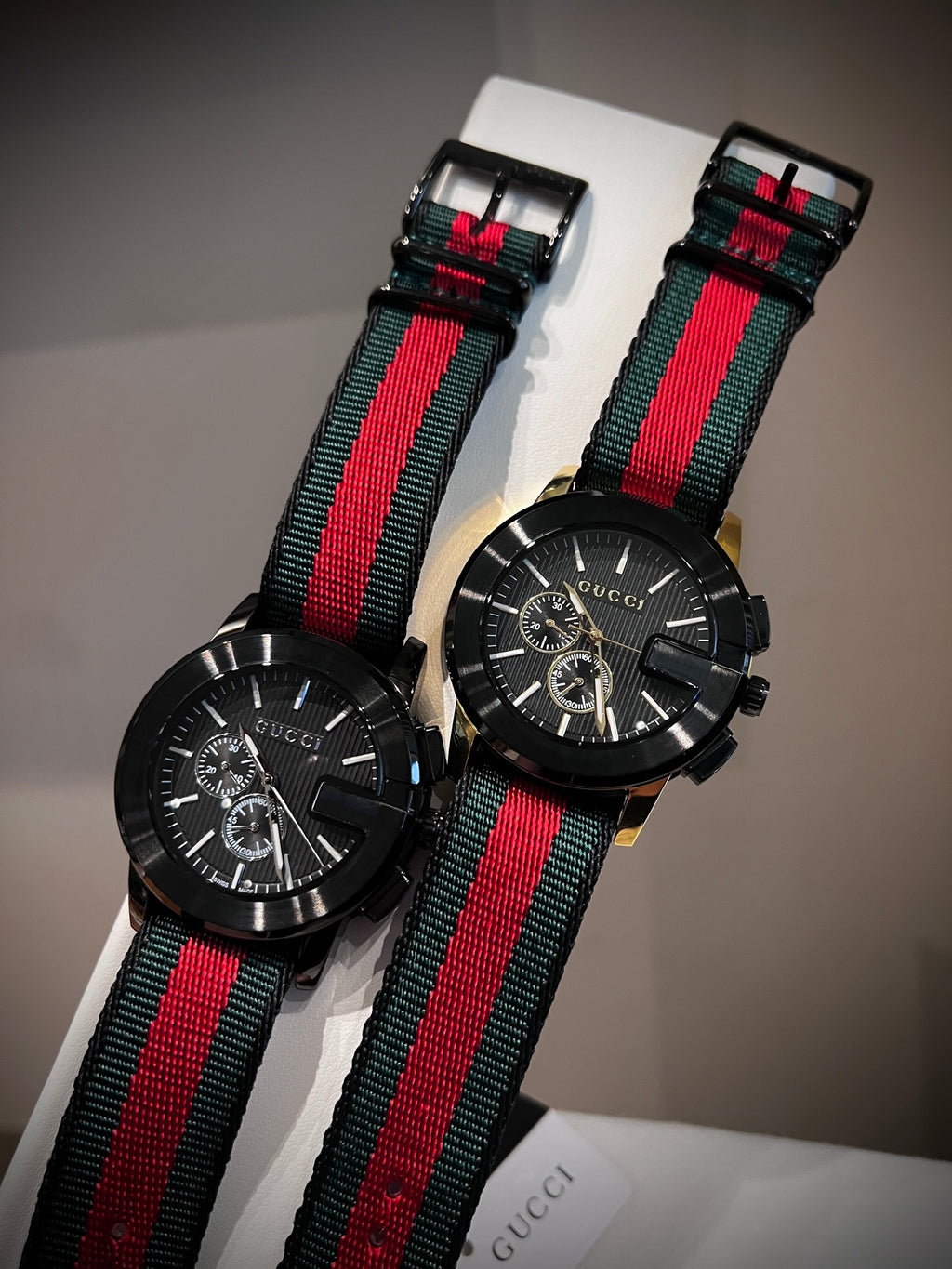 Black multi-dial watch with red and green striped strap