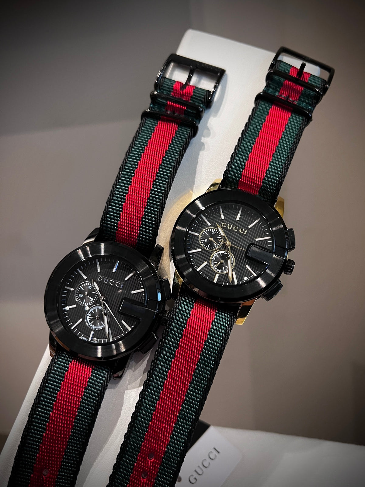 Black multi-dial watch with red and green striped strap